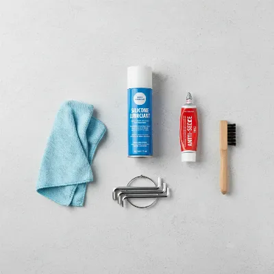 Essential tools and lubricants for maintaining a hitch bike rack, including a spray lubricant and wrench.