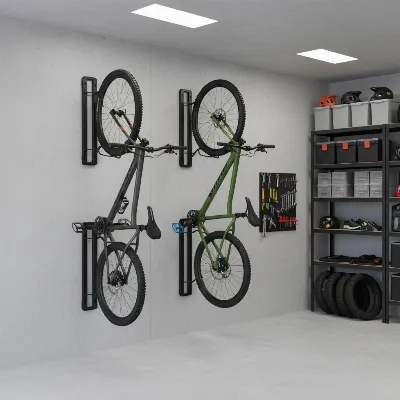 A clean, organized garage wall featuring multiple mountain bikes stored vertically on space-saving wall mounts. The bikes are staggered slightly to prevent handlebar interference.